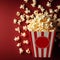 Delicious popcorn scattering from a red striped carton box on a dark red background with copy space