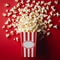 Delicious popcorn scattering from a red striped carton box on red background with copy space