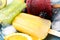 Delicious popsicle, ice cubes and fresh fruits on plate, closeup