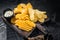 Delicious Potato chips - Crinkle, homemade, hot BBQ on a wooden board. Black background. Top view