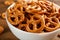 Delicious pretzel crackers in bowl on wooden table, closeup