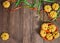 Delicious pumpkins, green and orange ribbons, orange plate and pumpkin seeds on wooden background.