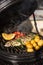 Delicious rainbow trout fish with tomatoes, potatoes and lemon cooking on hot flaming grill. Barbecue. Restaurant