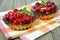 Delicious raspberries tarts on tablecloth on wooden table