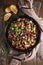 Delicious ratatouille in baking dish served on wooden table, flat lay