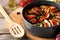 Delicious ratatouille in round baking pan and spatula on table, closeup