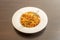 Delicious recipe for spaghetti with bolognese sauce seasoned with oregano and grated cheese on a white deep plate