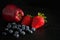 Delicious Red Apple, Strawberries and Blueberries on Dark Background