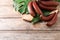 Delicious red baby bananas on wooden table, flat lay. Space for text