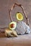 Delicious and ripe avacado stands on natural stones. Composition from balancing objects. Monochrome vertical creative composition