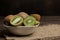 Delicious ripe many kiwi fruit and kiwi sectioned in a bowl on a brown wooden table. space for text