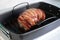 Delicious roast turkey crown wrapped with bacon in a black baking tray