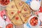 Delicious Russian pancakes with cherries and strawberries and a mug of milk on a bright table, top view, selective focus.