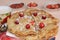 Delicious Russian pancakes with cherries and strawberries and a mug of milk on a bright table, top view, selective focus.