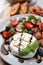 Delicious salad with brie cheese, berries and balsamic vinegar on table, closeup