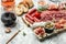 delicious salami, pieces of sliced prosciutto crudo, sausage and wine. Meat platter. Mixed delicatessen of meat snacks. place for