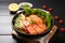 Delicious salmon salad bowl, showcasing raw sashimi, lemon, and spices