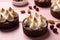 Delicious salted caramel chocolate meringue tarts and nuts on pink wooden table, closeup