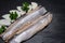 Delicious Salted Herring garnished with Yellow Onion slices and Fresh Parsley. Natural black stone. Clupea harengus.