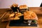 Delicious sandwich or burger with portion of golden potato french fries on a wooden dark board