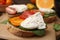 Delicious sandwich with burrata cheese and tomatoes on board, closeup