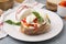 Delicious sandwich with burrata cheese and tomatoes on grey table, closeup