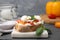 Delicious sandwich with burrata cheese and tomatoes on grey wooden table, closeup