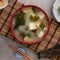 Delicious savory Japanese miso soup in a black bowl for eating