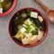 Delicious savory Japanese miso soup in a black bowl for eating