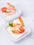 Delicious shrimp canapes with tomato and arugula on a light background. Festive appetizer with seafood.