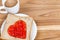 Delicious slice of bread with strawberry jam heart shape