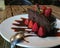 Delicious slice of rich dark chocolate cake with chocolate icing and fresh red strawberries. On wooden table.