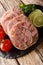 Delicious sliced Head cheese or brawn served with tomatoes, lime and cilantro closeup on a slate board. vertical