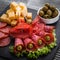 Delicious sliced salami on a stone plate wooden background