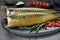 Delicious smoked mackerels and spices on dark grey table, closeup