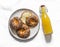 Delicious snack - cheese rolls and a bottle of freshly squeezed orange juice on a light background, top view