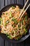 Delicious soba with vegetables and sesame close-up on a plate. V