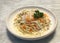 Delicious spaghetti pasta cream cheese white sauce with crab, egg on top, served in white place, restaurant food