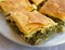 Delicious `spanakopita` traditional Greek spinach and feta pie portions close up