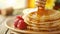 Delicious stack of pancakes adorned with fresh berries and drizzled with sweet honey on a plate