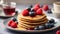 Delicious stack of pancakes close-up with fresh blueberry and raspberry