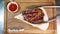 Delicious steak. Beef steak on wooden plate. Medium-roasted steak on a wooden board with sauce.