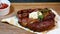 Delicious steak. Beef steak on wooden plate. Medium-roasted steak on a wooden board with sauce.