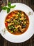 Delicious stew - aubergine with tomatoes and chickpeas on wooden table