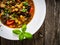 Delicious stew - aubergine with tomatoes and chickpeas on wooden table