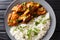 Delicious stewed ribs in a spicy sauce served with white rice close-up on a plate. horizontal top view