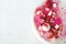 Delicious strawberry cheesecake, fresh berries, coconut, and sweet decor element on top, white concrete background
