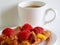 A delicious Strawberry Danish pastry and a white cup of coffee on white background