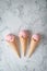Delicious strawberry ice cream and waffle cone on marble background, top view