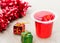 Delicious strawberry jelly and xmas gift box on wooden table. Sweet fruity pudding in transparent cup